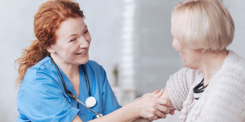 Pflegekraft untersucht ältere Patientin