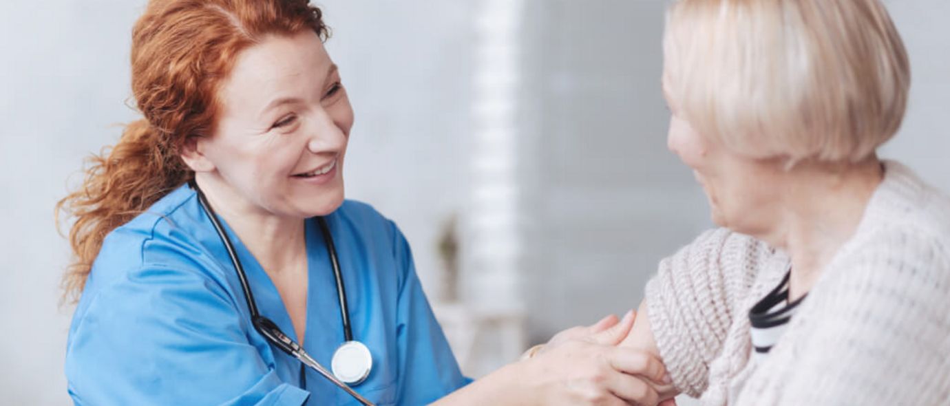 Pflegekraft untersucht ältere Patientin