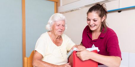 Therapeutin unterstützt ältere Patientin in der Ergotherapie