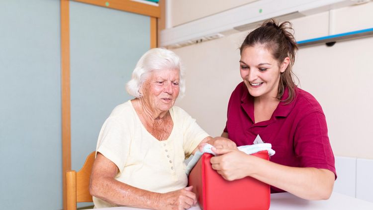 Therapeutin unterstützt ältere Patientin in der Ergotherapie