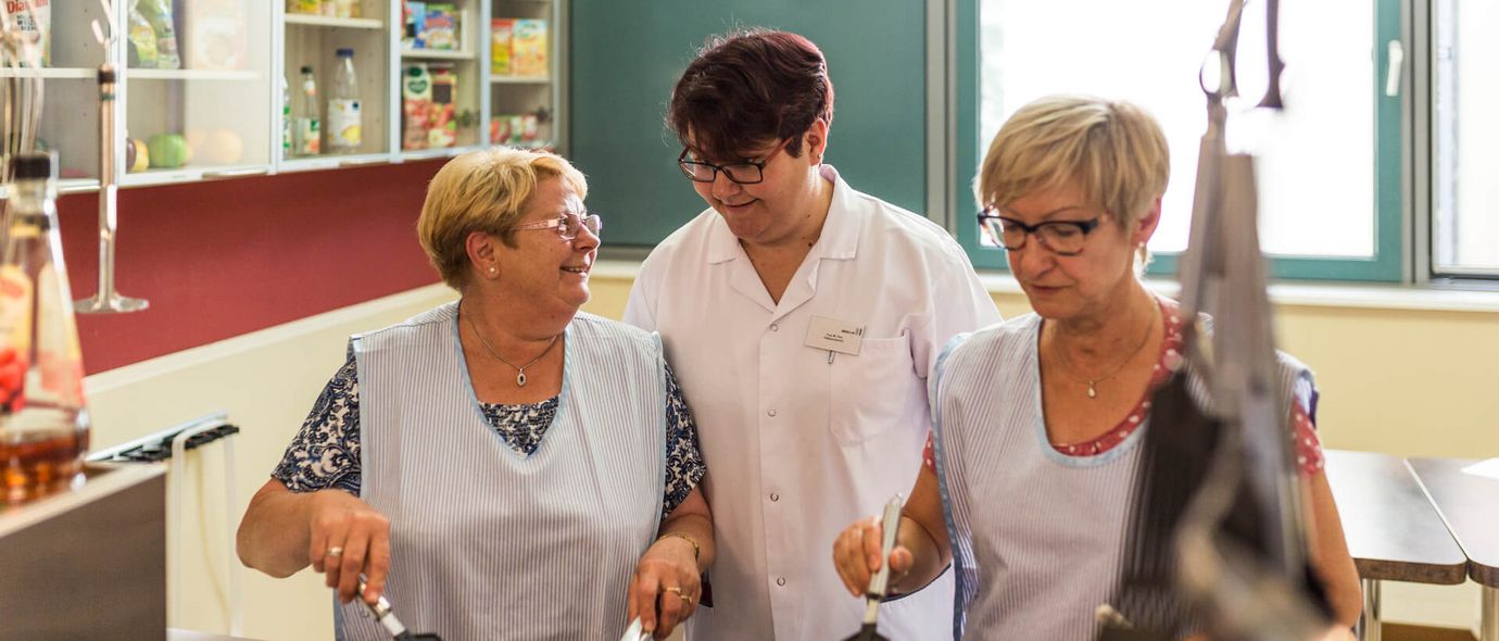 Patienten und Therapeutin kochen in der Lehrküche