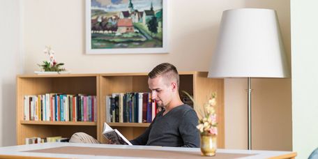 Patientin liest in der klinikeigenen Bibliothek