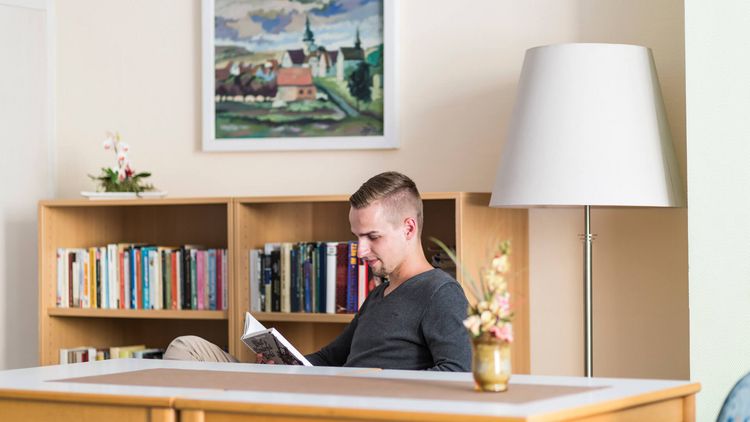 Patientin liest in der klinikeigenen Bibliothek