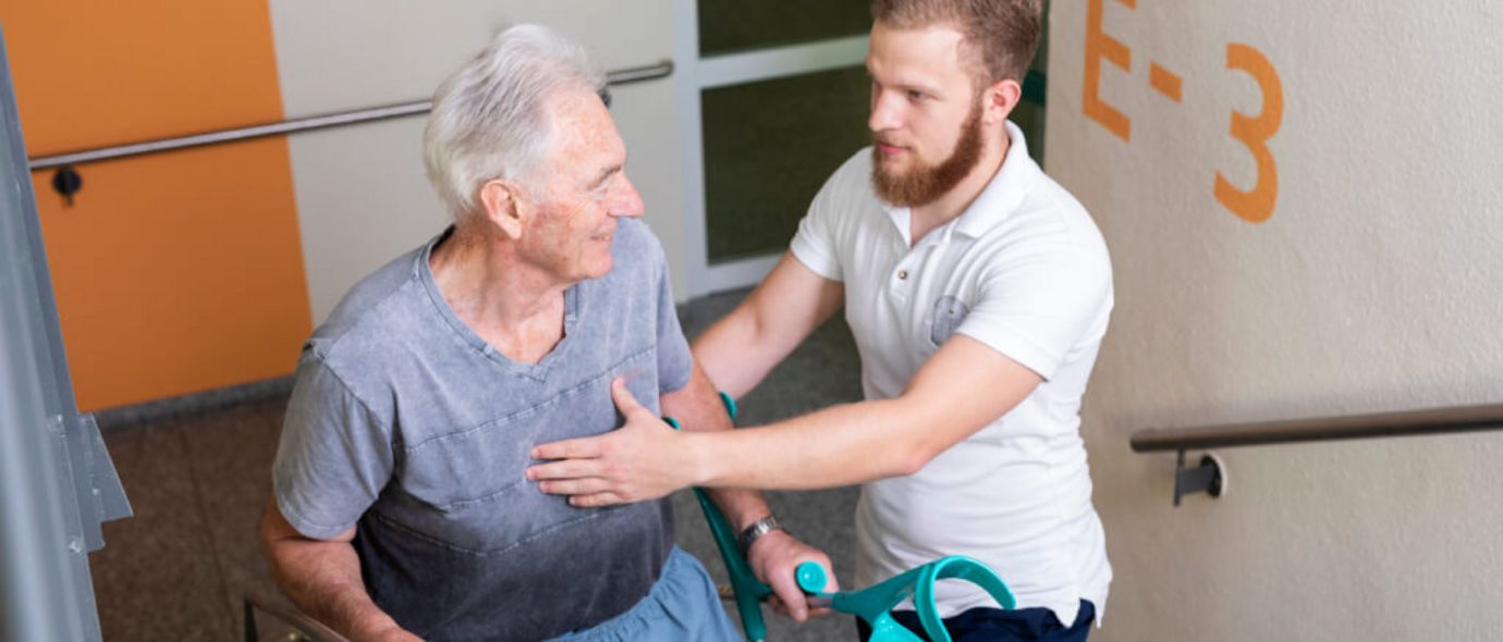 Therapeut und älterer männlicher Patient trainieren Treppensteigen