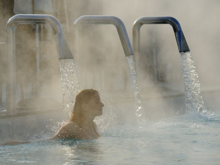 Junge Frau entspannt sich im Außenbecken eines Thermalbades