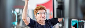Ältere Patientin stärkt ihre Muskeln an Geräten in der medizinischen Trainingstherapie